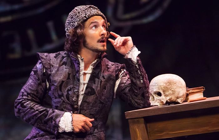 Man at table tooking thoughtful with skull on table